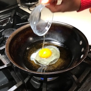 Egg frying in pan for easy and authentic shrimp pad Thai recipe
