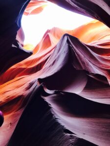 purple and orange waves sandstone formation Lower Antelope Canyon with sunlight and sky