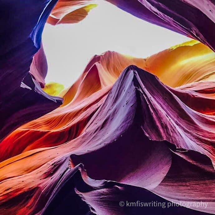 purple and orange waves sandstone formations with opening to the sky