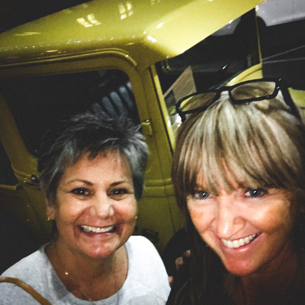 Two women standing in front of yellow truck at Pack's Tavern in Asheville, NC