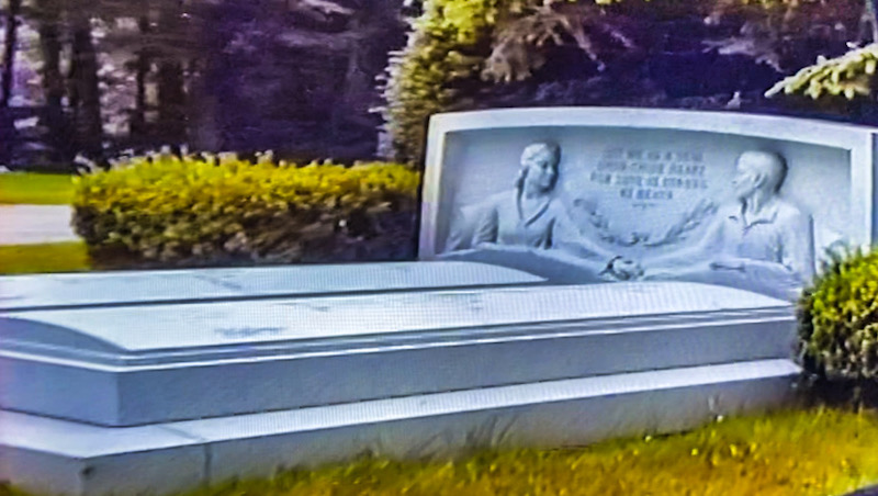 Cemetery headstone of man and woman in bed