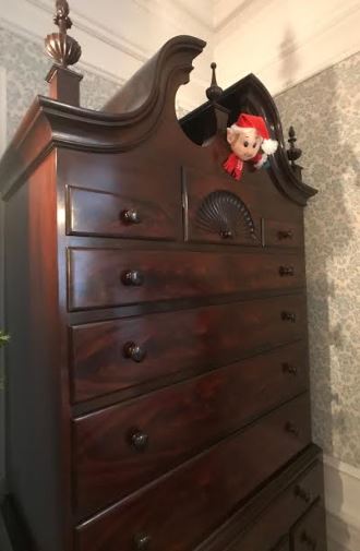 elf hiding in a dresser bureau