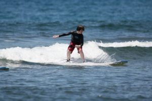 Boy surfing in Maui Hawaii