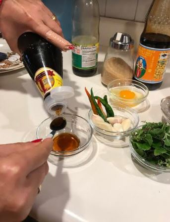 Measuring soy sauce for shrimp pad Thai recipe