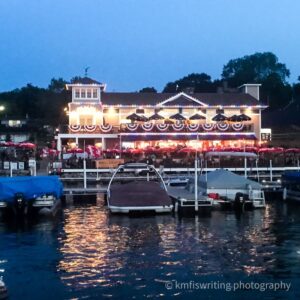 Lakeside restaurant lit up and night and decorated in 4th of July banners