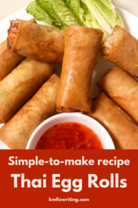 Egg rolls on serving platter with garnish and sauce
