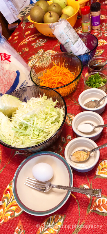 Ingredients to make egg rolls sitting in bowls on a table