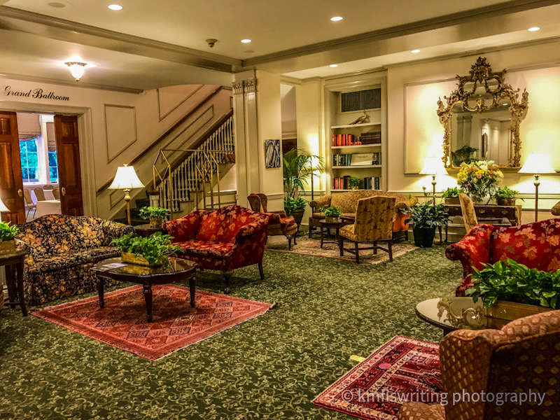 hotel lobby with chairs, tables, rugs and staircase