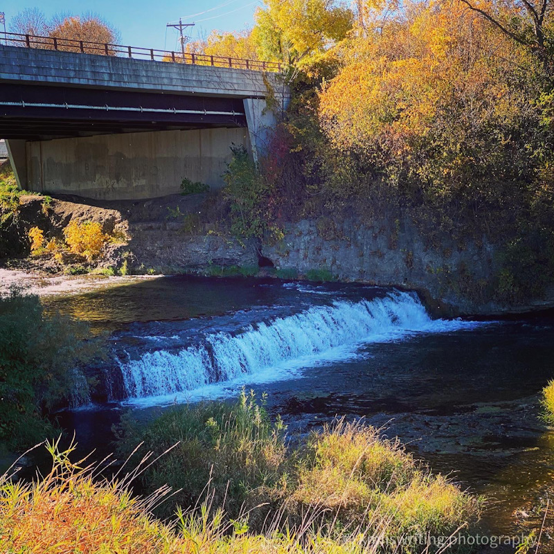Waterfall with an overpass bridge and fall colors