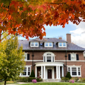 Fall foliage of red leaves framing a historic home on Summit Ave