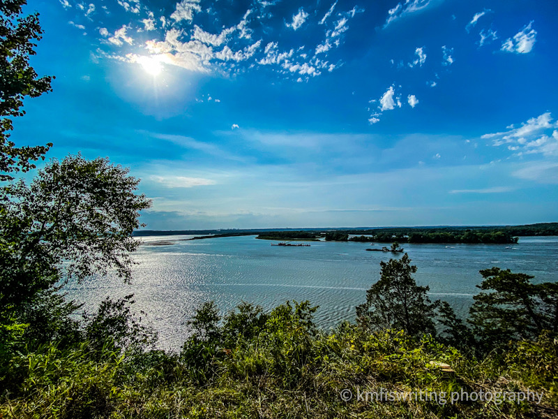Overlook scenic view of Mississippi River with a blue sky and bright sun