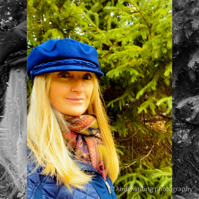 Woman wearing a navy hat standing in front of an evergreen tree