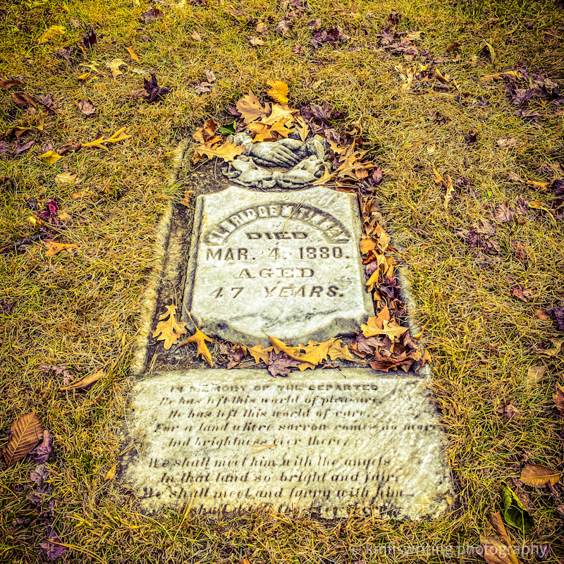 Historic flat grave marker with fall foliage