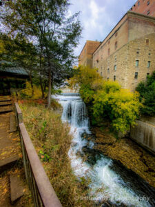 Urban waterfalls and fall foliage next to a building