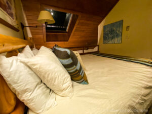 Bed with lots of pillows with a skylight
